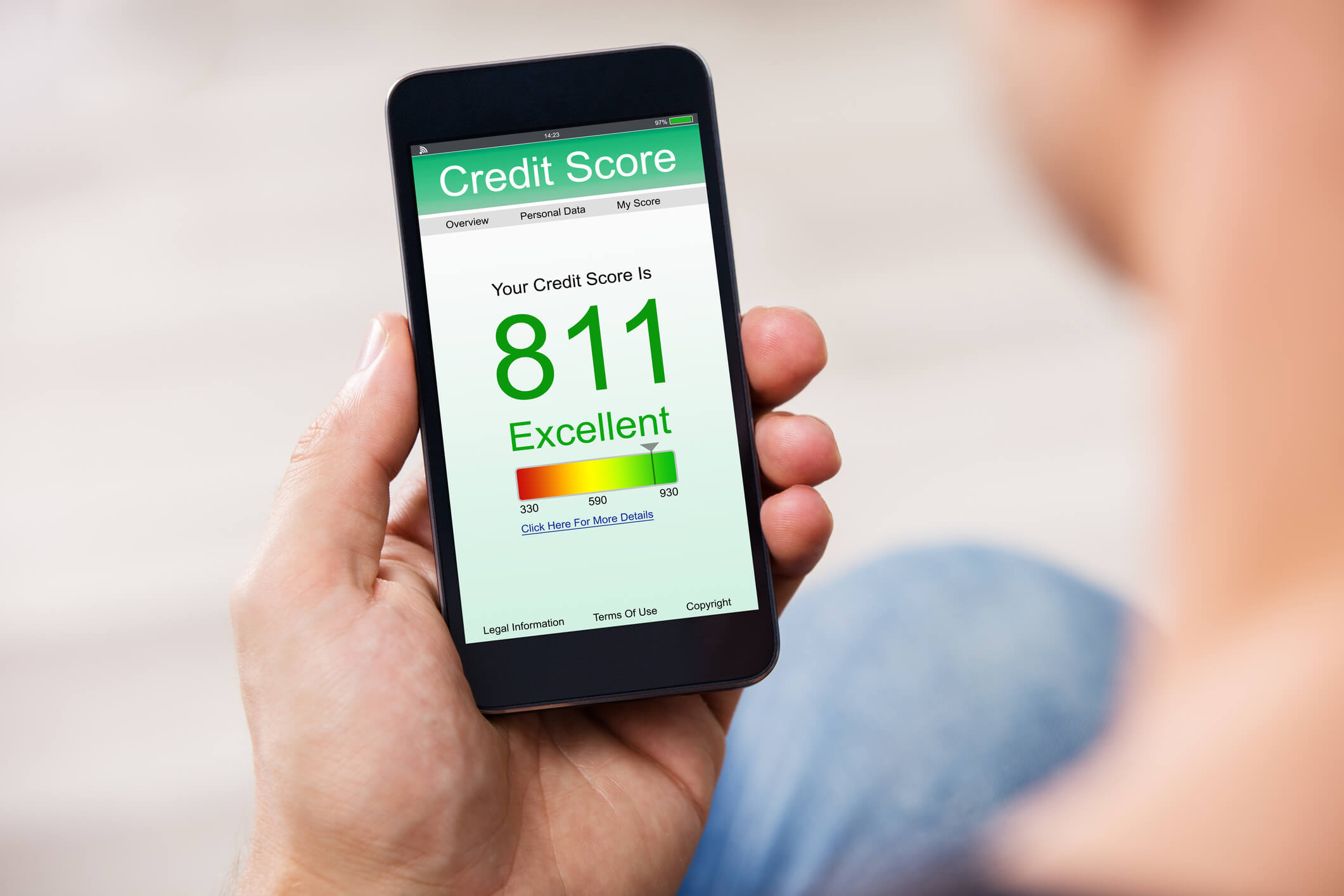 man holding a phone in his hand with his credit score on the screen, the credit score is 811